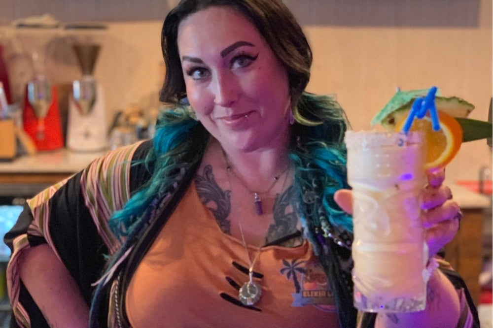General Manager Cassandra Abercrombie with a tiki mocktail at Elixir Lounge