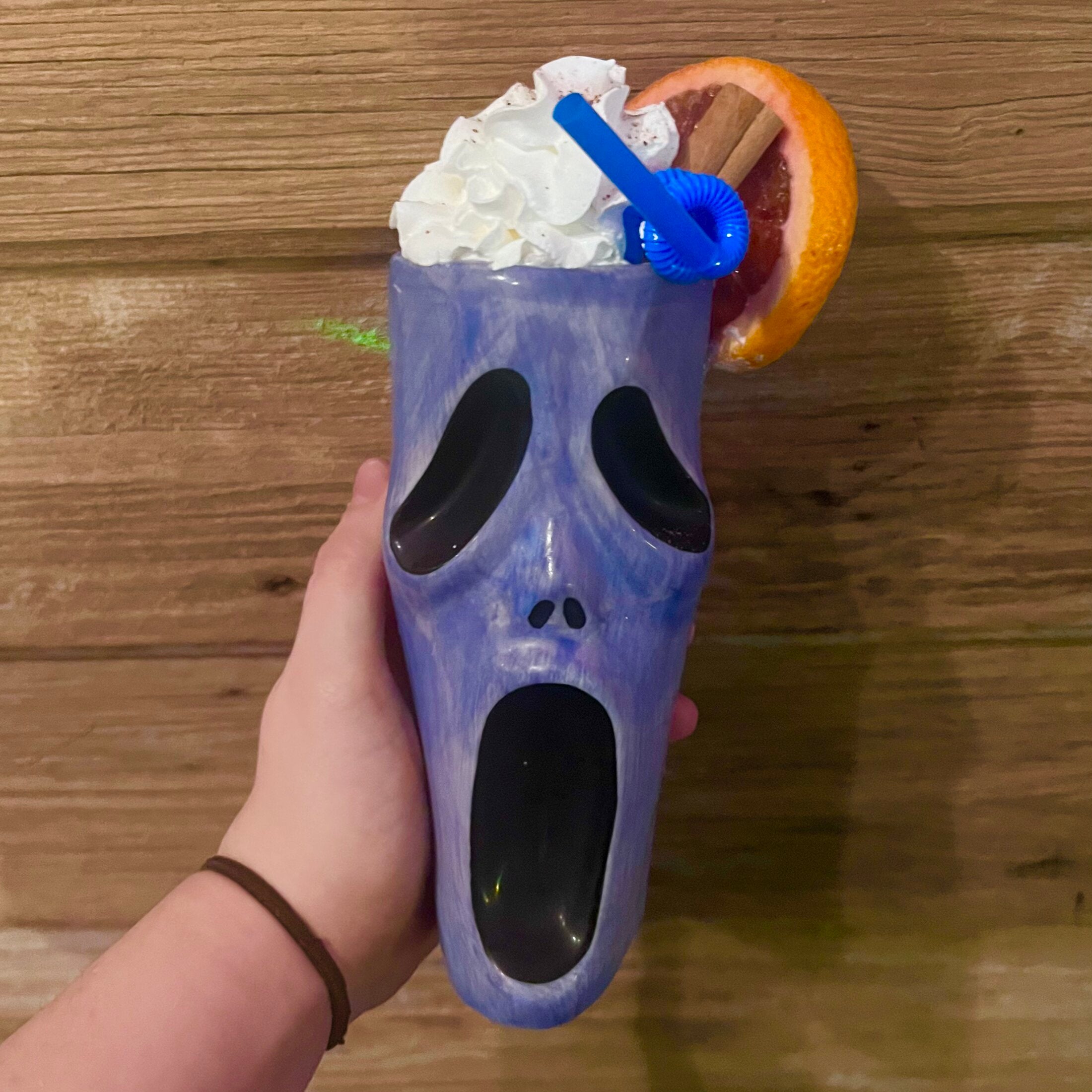 Purple ghost-face novelty mug drink with grapefruit and cinnamon garnish at Elixir Lounge.