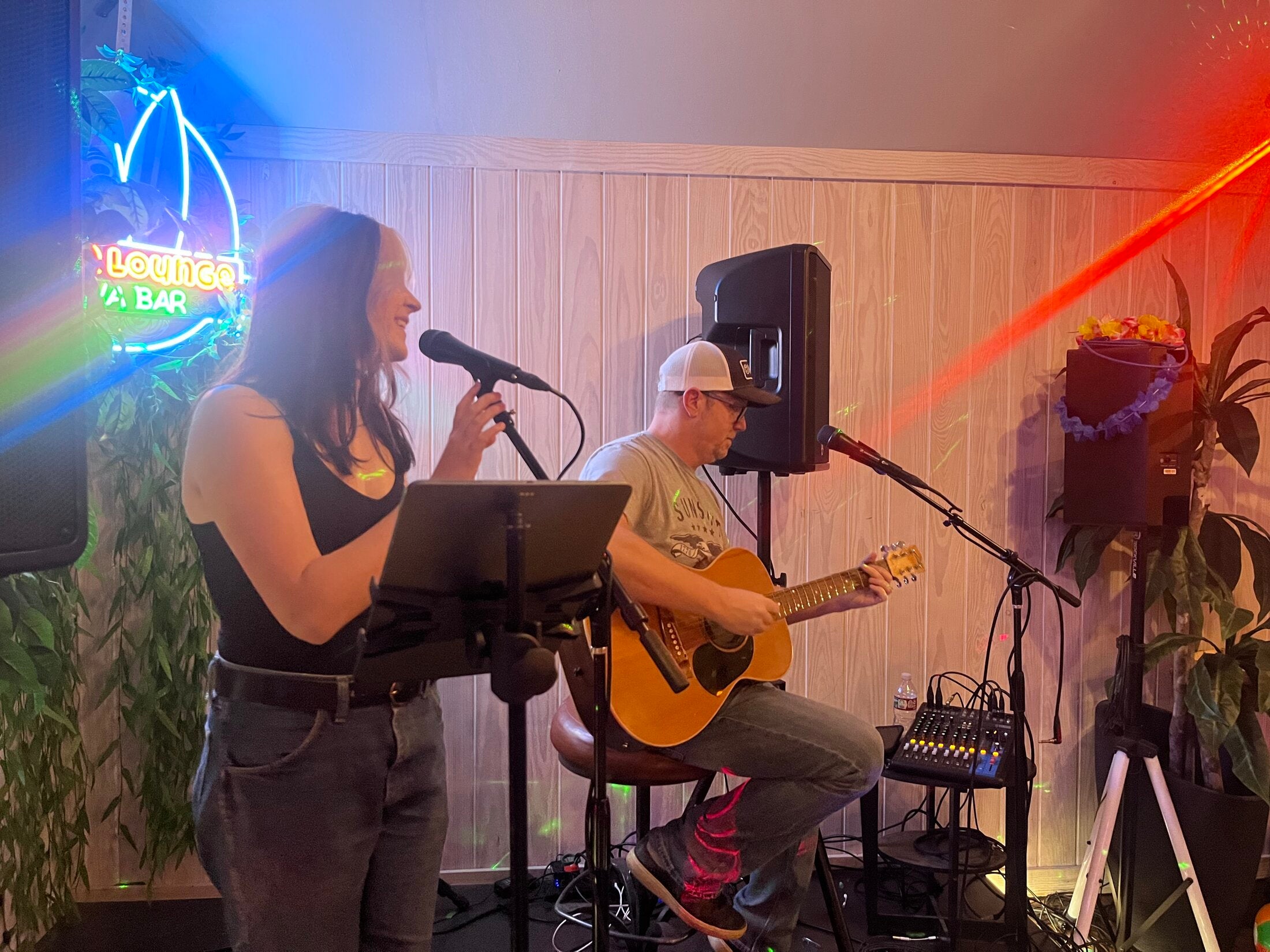 Singer and acoustic guitarist performing live under the Lounge Kava Bar neon sign at Elixir Lounge.